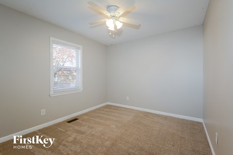 a bedroom with a ceiling fan and a window