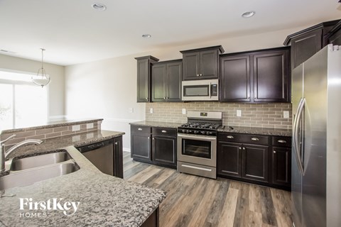 A kitchen with dark brown cabinets and stainless steel appliances.