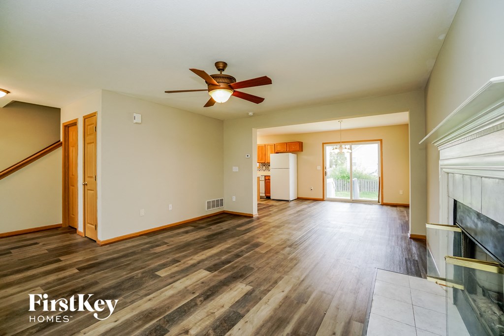 A spacious room with wood flooring and a ceiling fan.