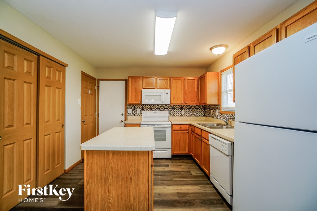 A kitchen with wooden cabinets and a white refrigerator.