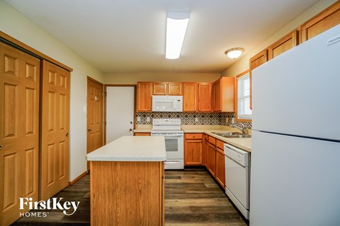 A kitchen with wooden cabinets and a white refrigerator.