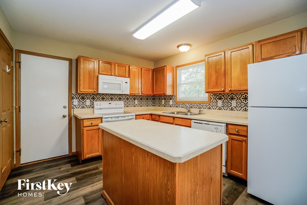 A kitchen with wooden cabinets and a white fridge.