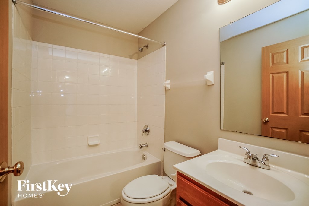 A bathroom with a white sink, toilet, and tub.