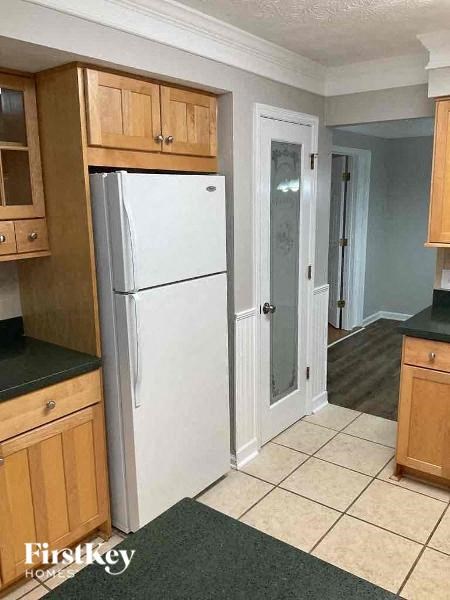 a kitchen with a white refrigerator and a door
