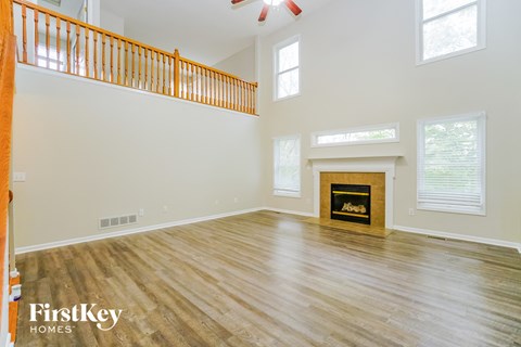 A spacious living room with a fireplace and wooden flooring.