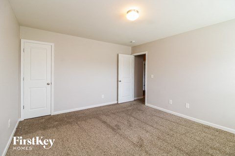 a spacious living room with carpet and white doors