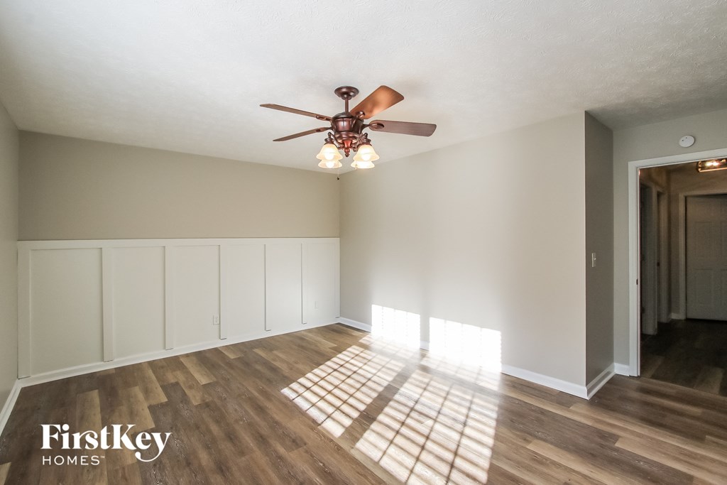A room with wooden floors and a ceiling fan.