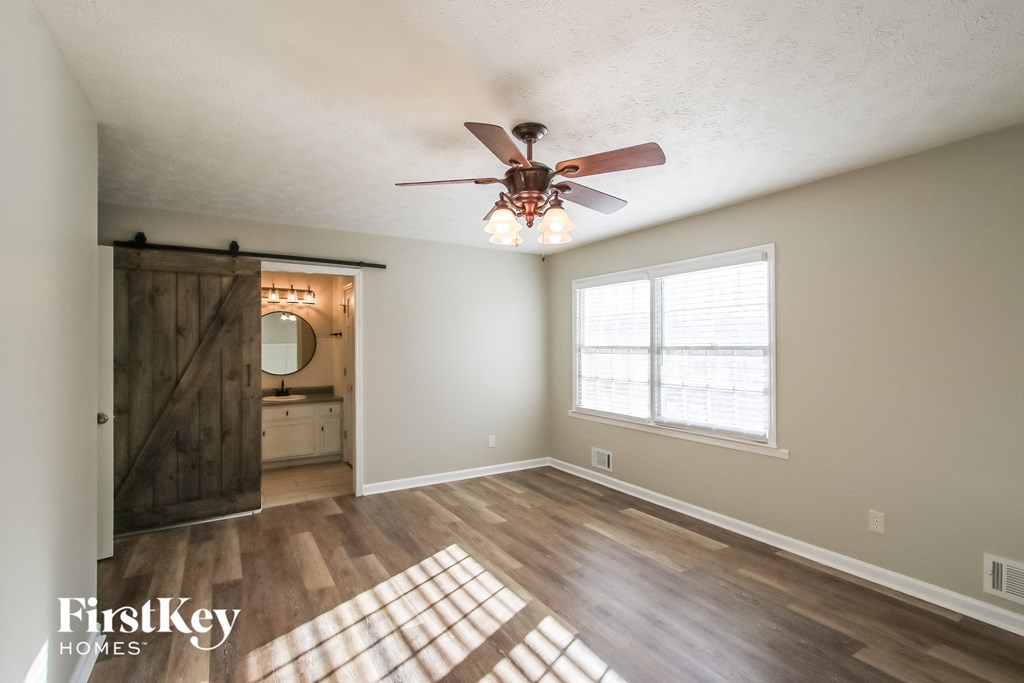 A room with a ceiling fan and a window.