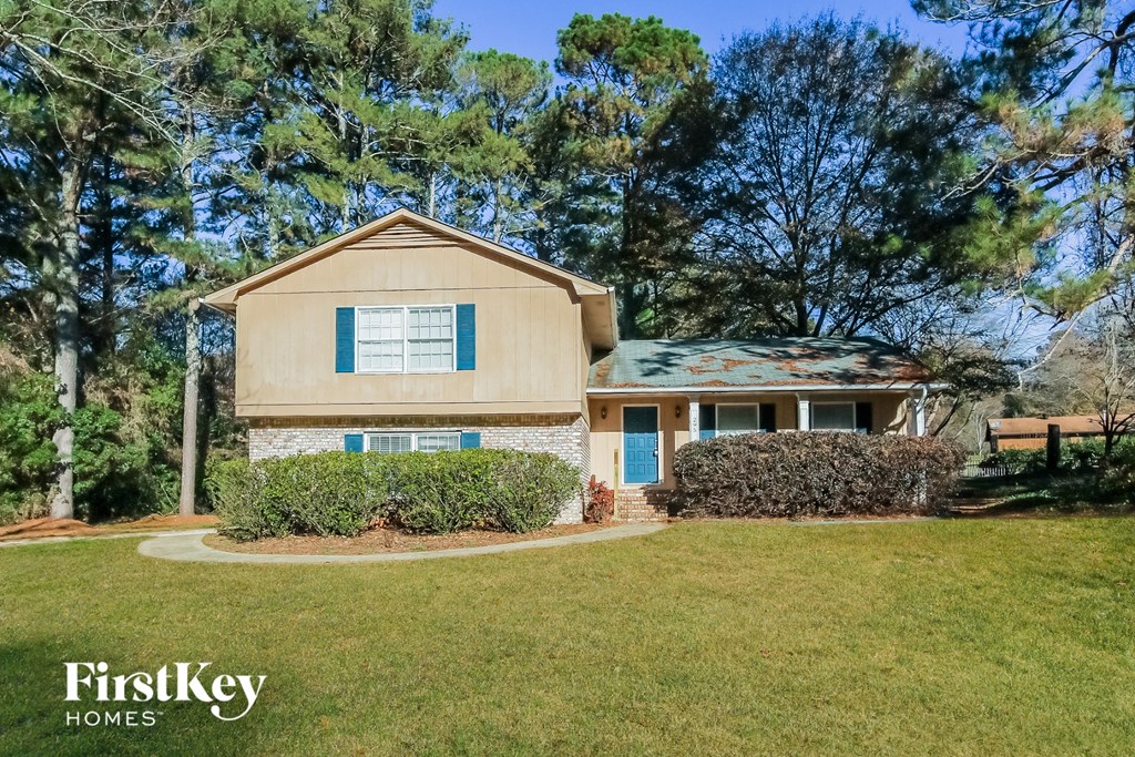 A house with a blue door and a sign that says FirstKey Homes.