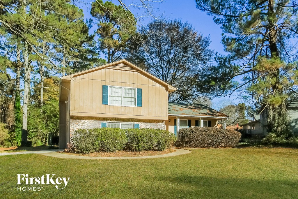 A house with a well-kept lawn in front of it.