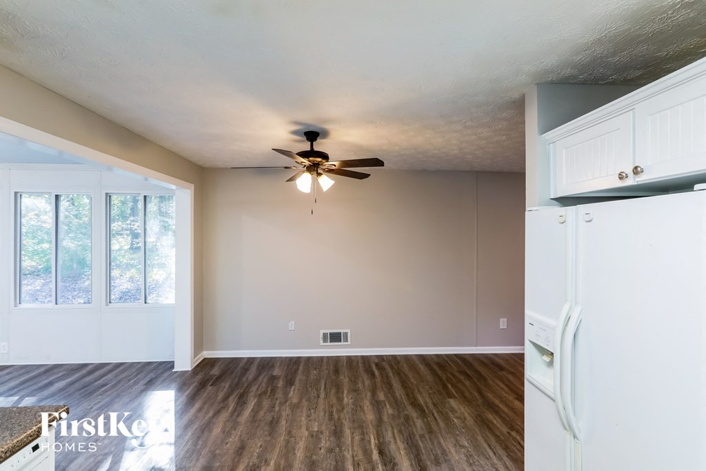 the living room of an empty house with a ceiling fan