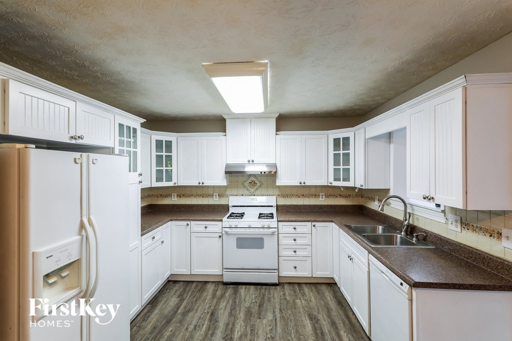 a kitchen with white cabinets and a stove and a sink