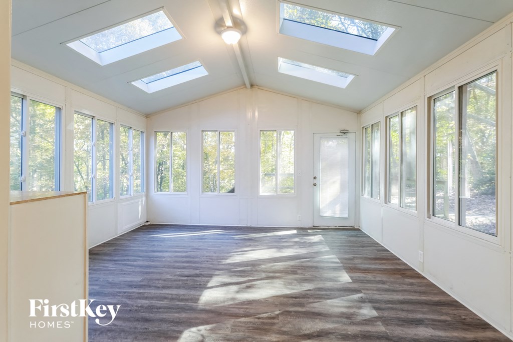 an empty sun room with windows and a door