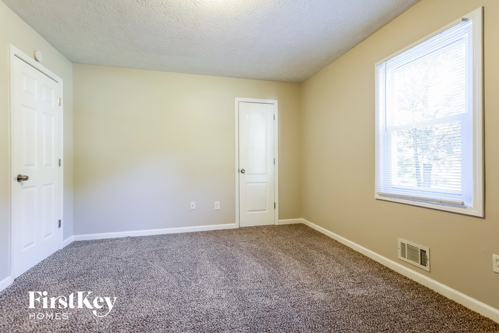 a room with carpet and a door and a window