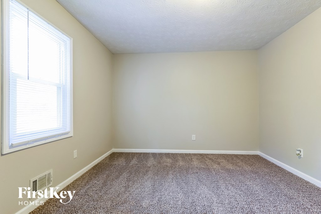 a empty room with carpet and a window