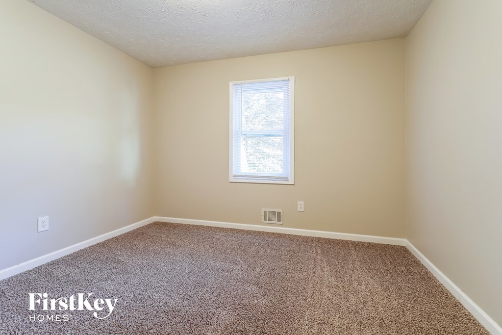 a empty room with carpet and a window