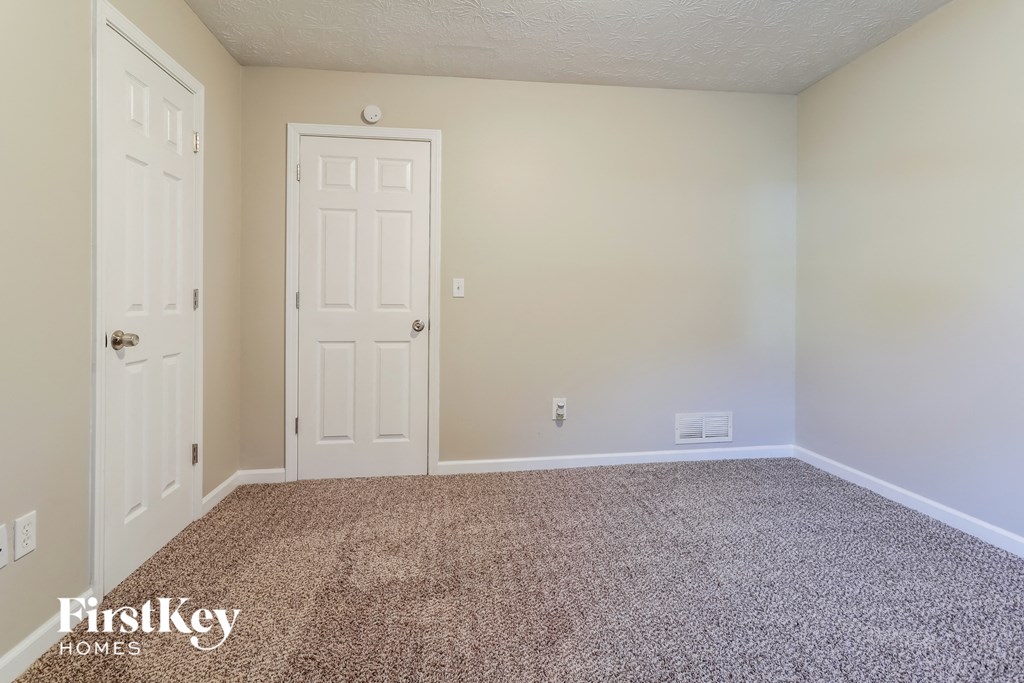 a empty room with a carpeted floor and a white door