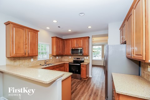 A kitchen with wooden cabinets and a FirstKey Homes logo.