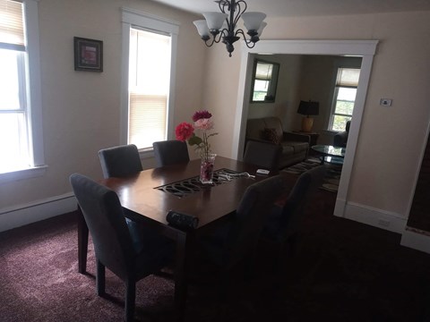 A dining room with a table and chairs.