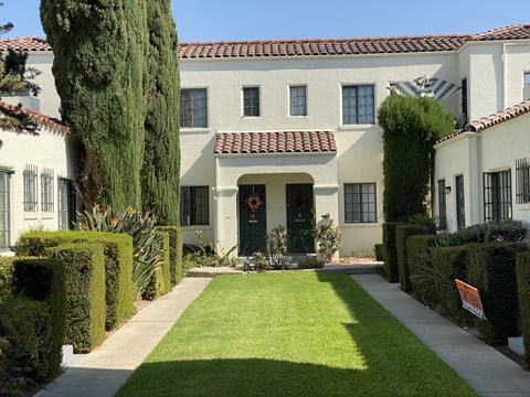 A white house with a red tile roof and a green door.