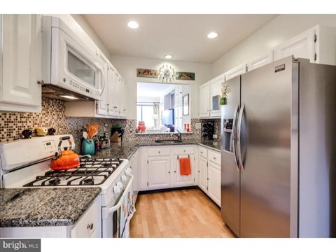 A kitchen with a stove top oven and a refrigerator.