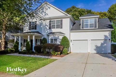 A large, two-story house with a garage is for sale.