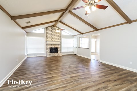 the living room with wood floors and a fireplace