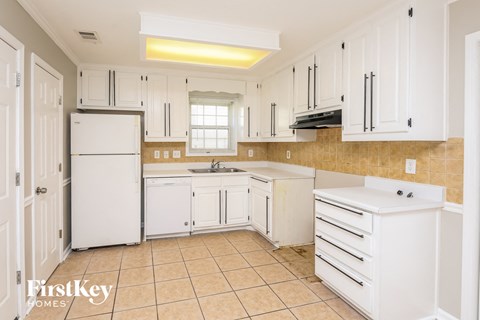 a white kitchen with white cabinets and white appliances
