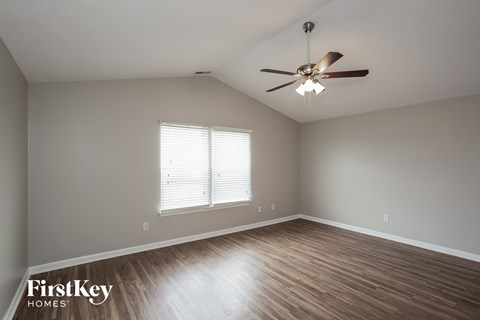 a living room with wood floors and a ceiling fan