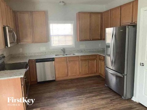 A kitchen with wooden cabinets and a stainless steel refrigerator.