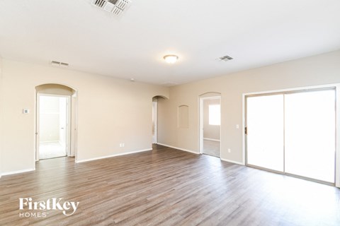 an empty living room with wood floors and white walls