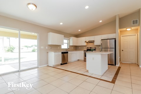 A kitchen with white appliances and cabinets is shown.