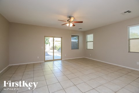 A spacious room with a ceiling fan and sliding glass doors.