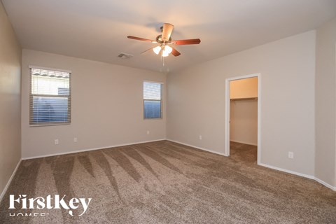 A spacious room with a ceiling fan and carpeted floor.