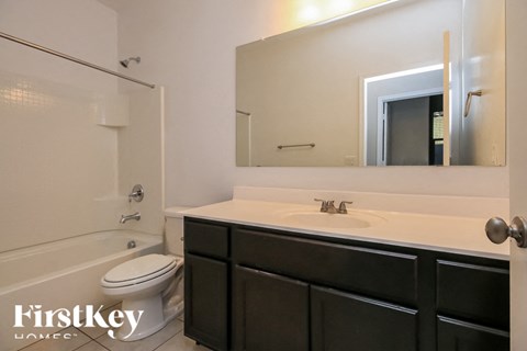 A bathroom with a white sink and a toilet.