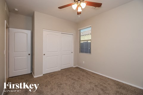 A room with a ceiling fan and two doors.