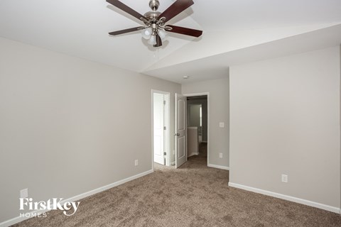 a living room with carpet and a ceiling fan