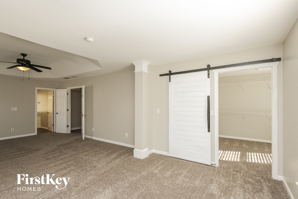 A spacious room with a ceiling fan and sliding door.
