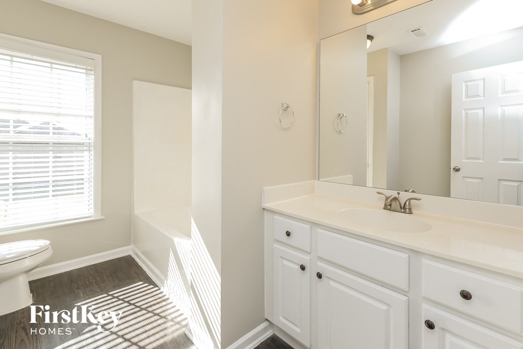 A bathroom with a white sink and cabinets.