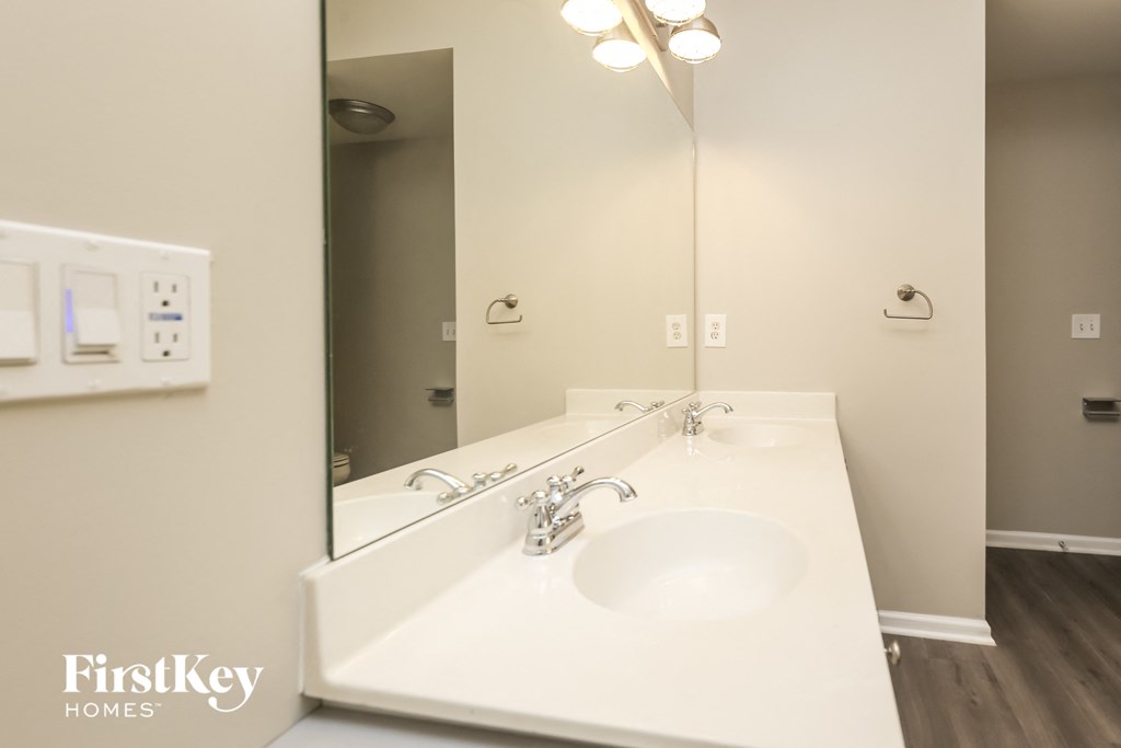 A bathroom with a double sink and a mirror.