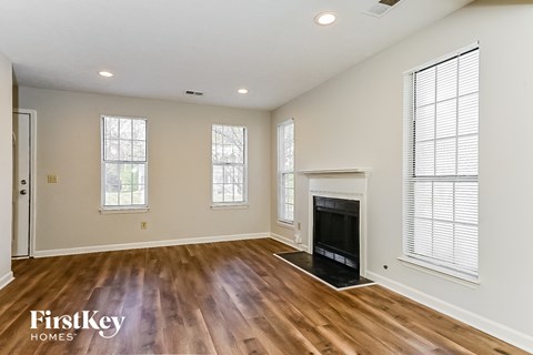 a living room with a fireplace and wooden floors