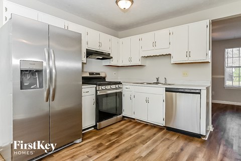 a kitchen with white cabinets and stainless steel appliances