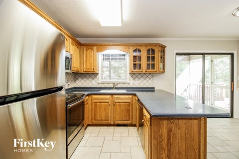 A kitchen with wooden cabinets and a stainless steel refrigerator.