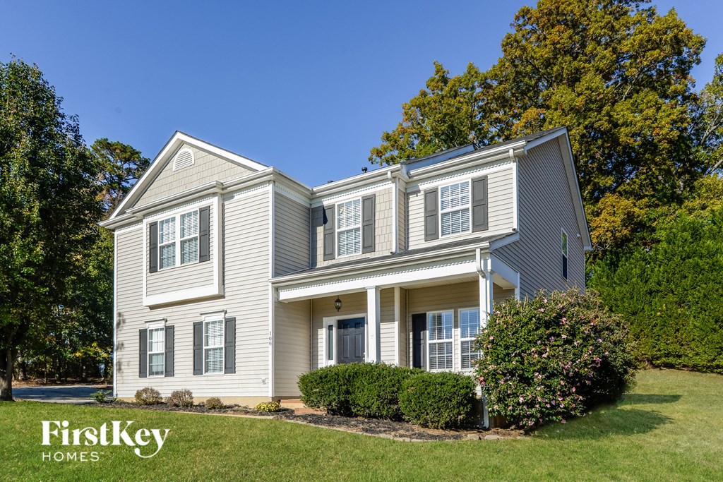 a white house with blue vinyl siding and a lawn