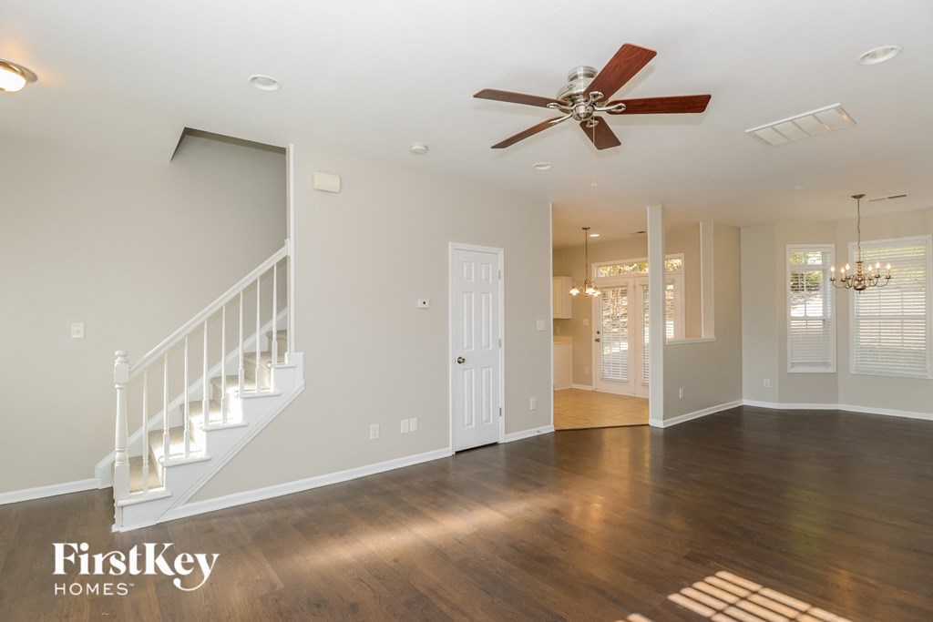 a living room with a staircase and a ceiling fan