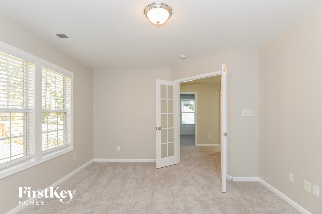 a bedroom with a door to a hallway and a carpeted floor
