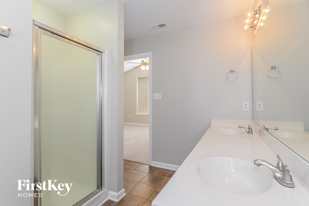 a bathroom with a sink and a shower and a mirror