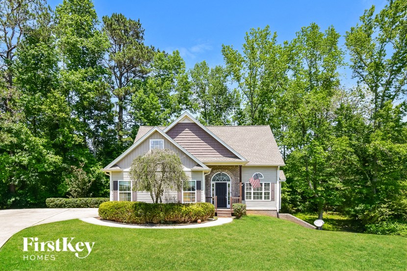 a house with a lawn and trees in front of it