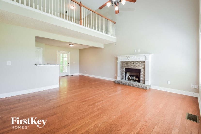 a living room with a fireplace and a ceiling fan