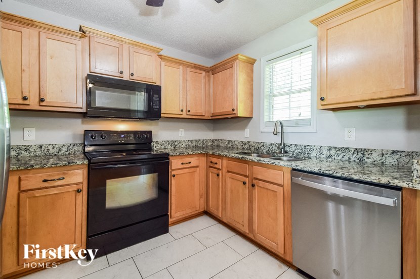 a kitchen with wooden cabinets and black appliances and granite counter tops